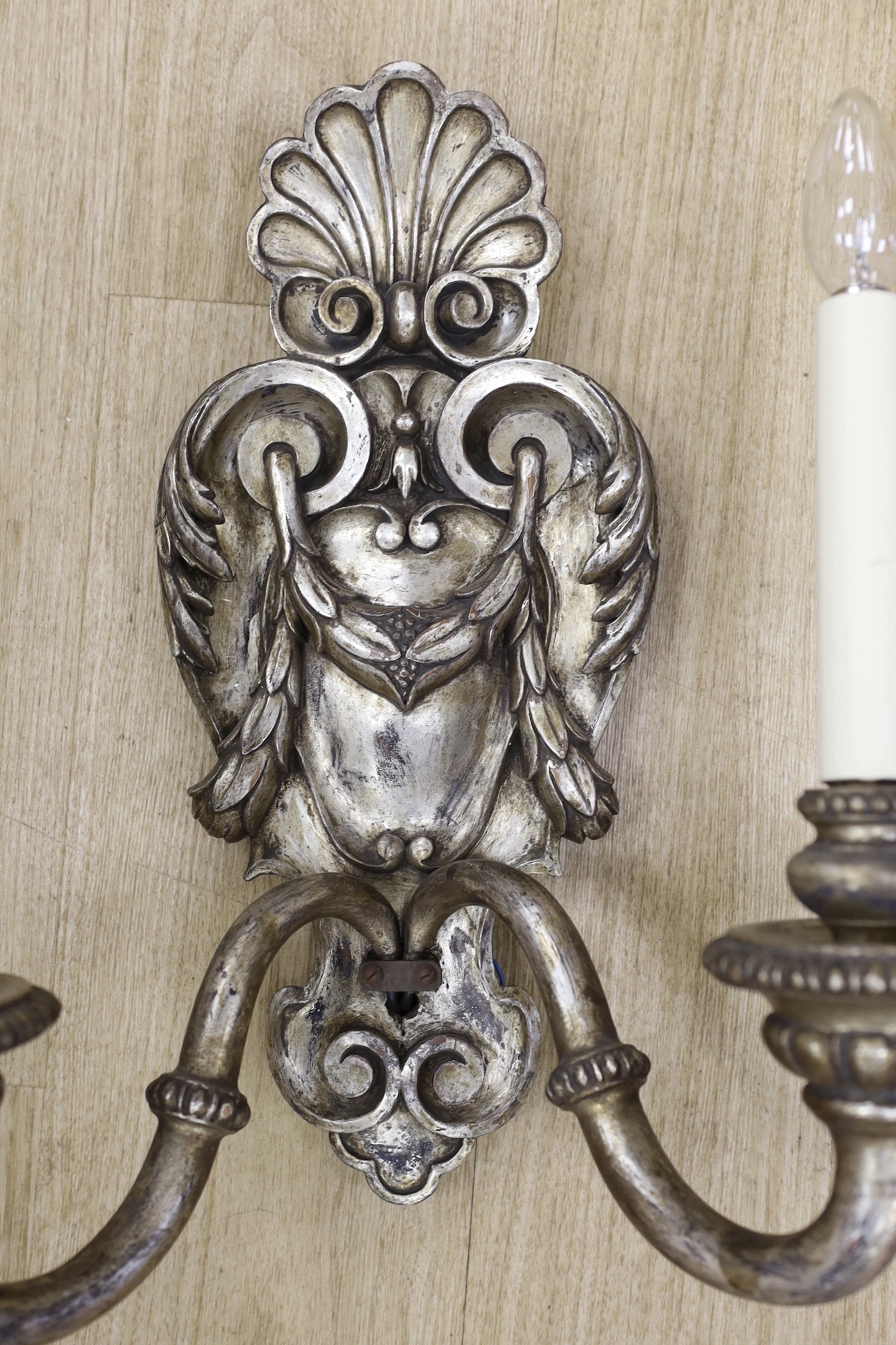 A pair of baroque style silvered wood two branch wall sconces